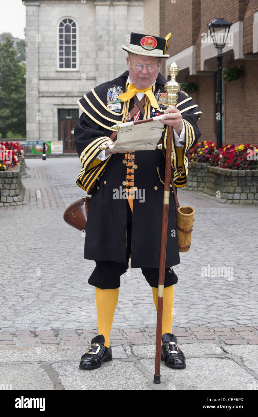 Truro, Cornwall, Inghilterra, Regno Unito. Town Crier John Sweetman in costume tradizionale lettura avvisi da una rotellina di scorrimento in una strada di città Foto Stock