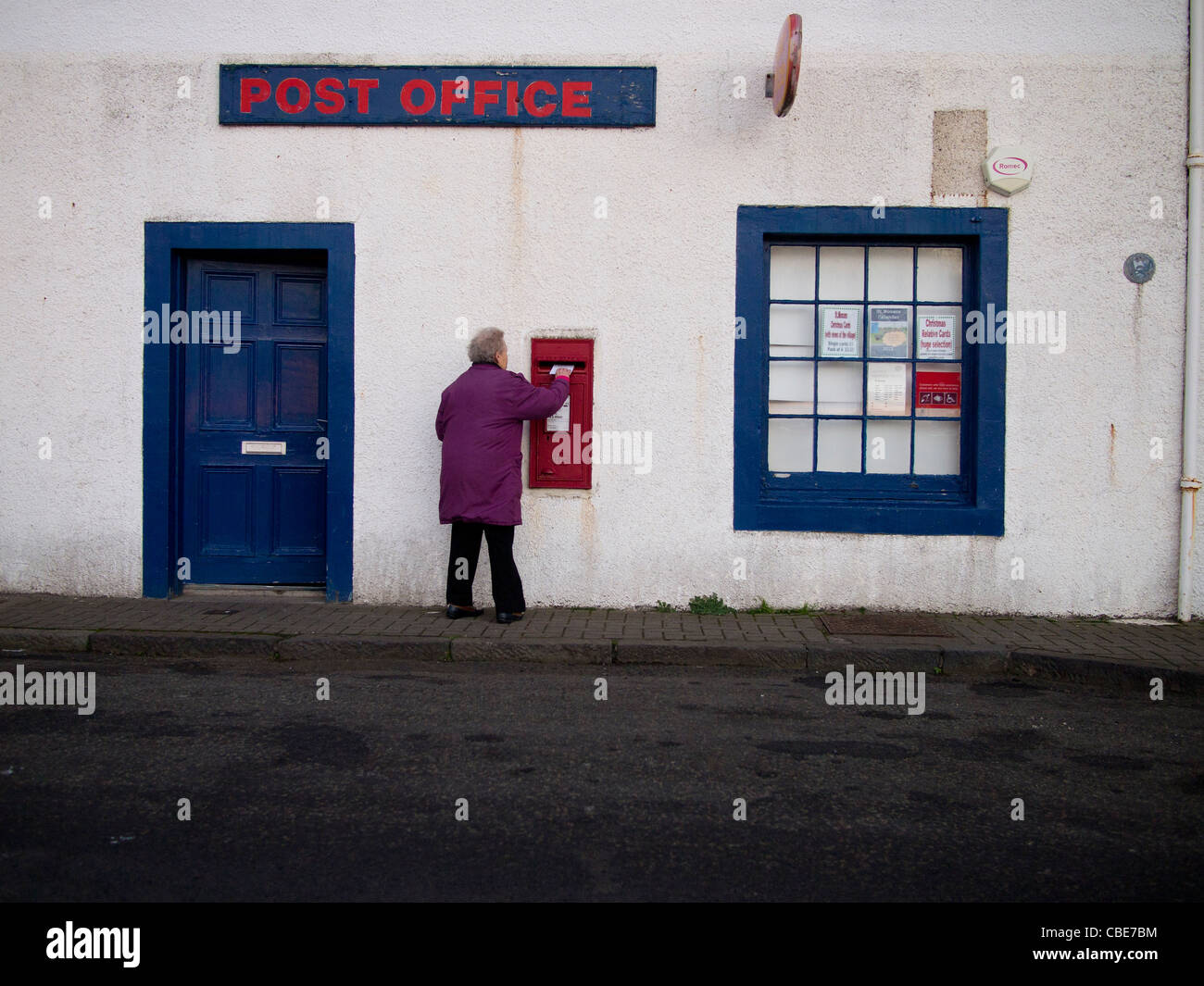 Donna inviare una lettera nella casella postale, St Monans, Fife Foto Stock