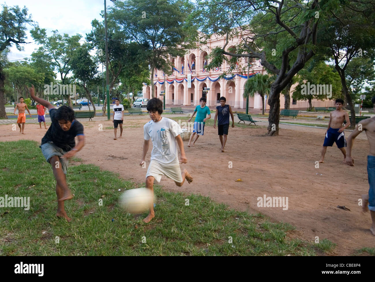 Bambini che giocano a piedi nudi in un piccolo parco di fronte al Museo della Cultura in Asunción, Paraguay Foto Stock