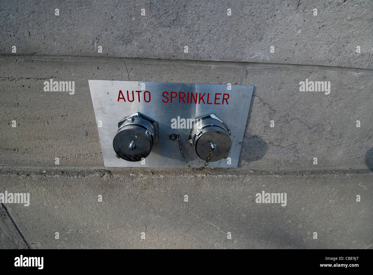 Un esterno doppio nipplo sprinkler sistema di alimentazione montato su una parete in cemento Foto Stock Un esterno doppio nipplo sprinkler sistema di alimentazione montato su una parete in cemento Foto Stock