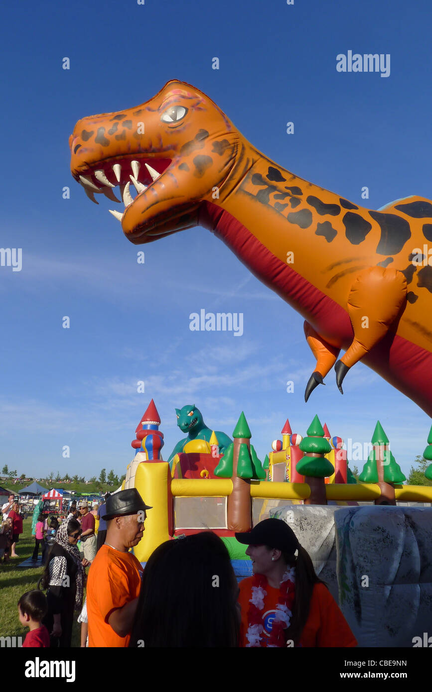 Un grande dinosauro gonfiabile impostato per i divertimenti per i bambini  in un luna park Foto stock - Alamy