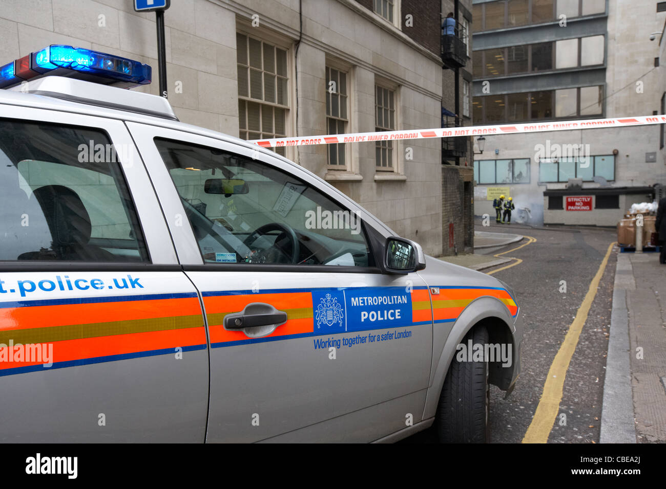 La Metropolitan Police squad automobile con la polizia cordone interno non cross nastro di segnalazione di incendi Londra Inghilterra Regno Unito Foto Stock