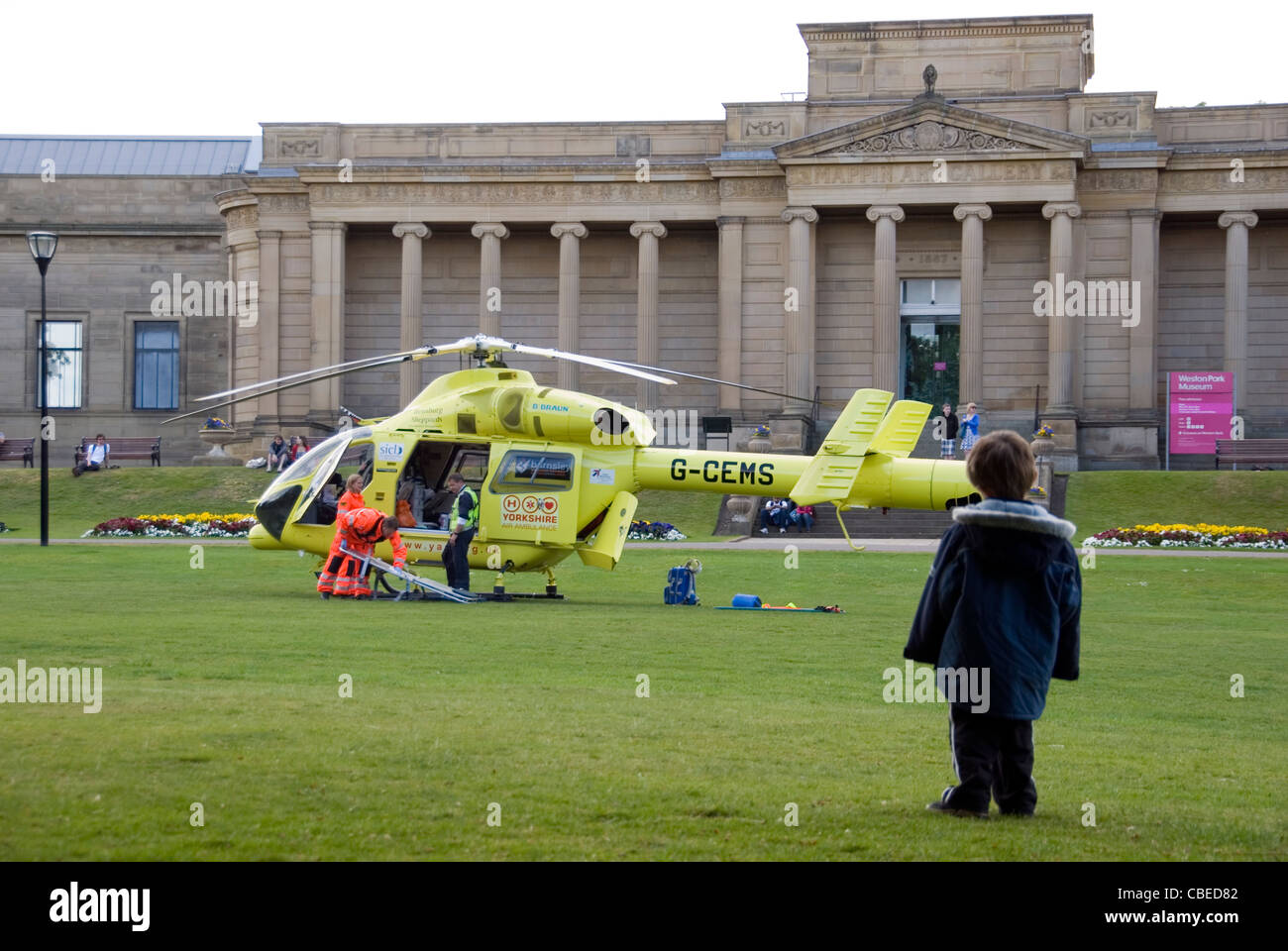 Ragazzo giovane orologi Sheffield Air Ambulance elicotteri equipaggio lo scarico in Weston Park, Sheffield, Regno Unito Foto Stock