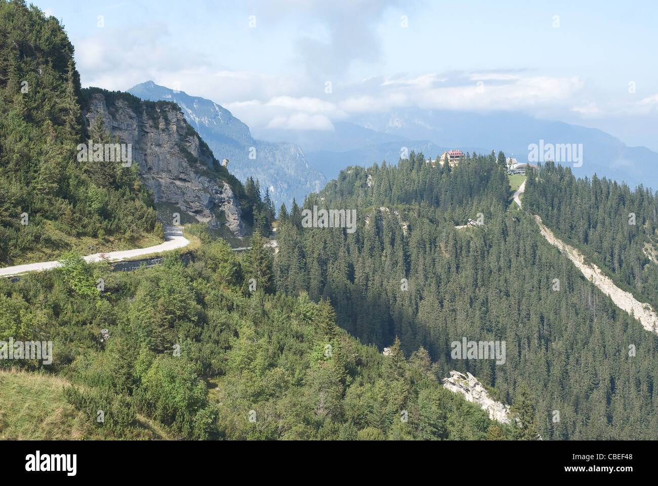 Country Road attraverso tedeschi di alto paesaggio di montagna Foto Stock
