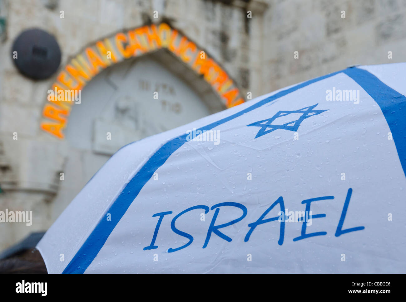 Close up di ombrello con bandiera Israeliana e III stazione della Via Dolorosa in bkgd. Gerusalemme la città vecchia Foto Stock