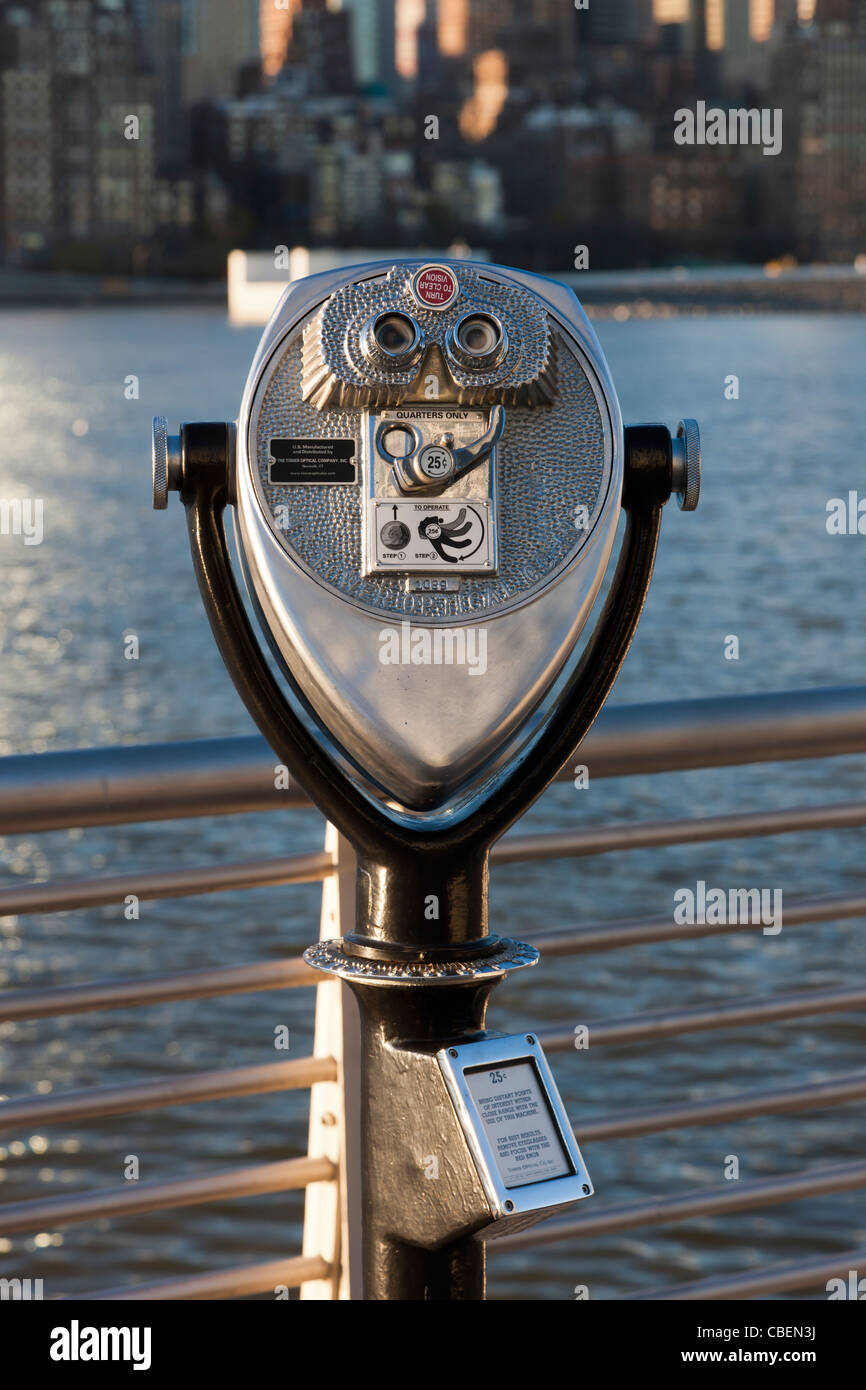 Un gettone visore binoculare in Gantry Plaza State Park offre vedute di Manhattan in tutta l'East River in New York City. Foto Stock