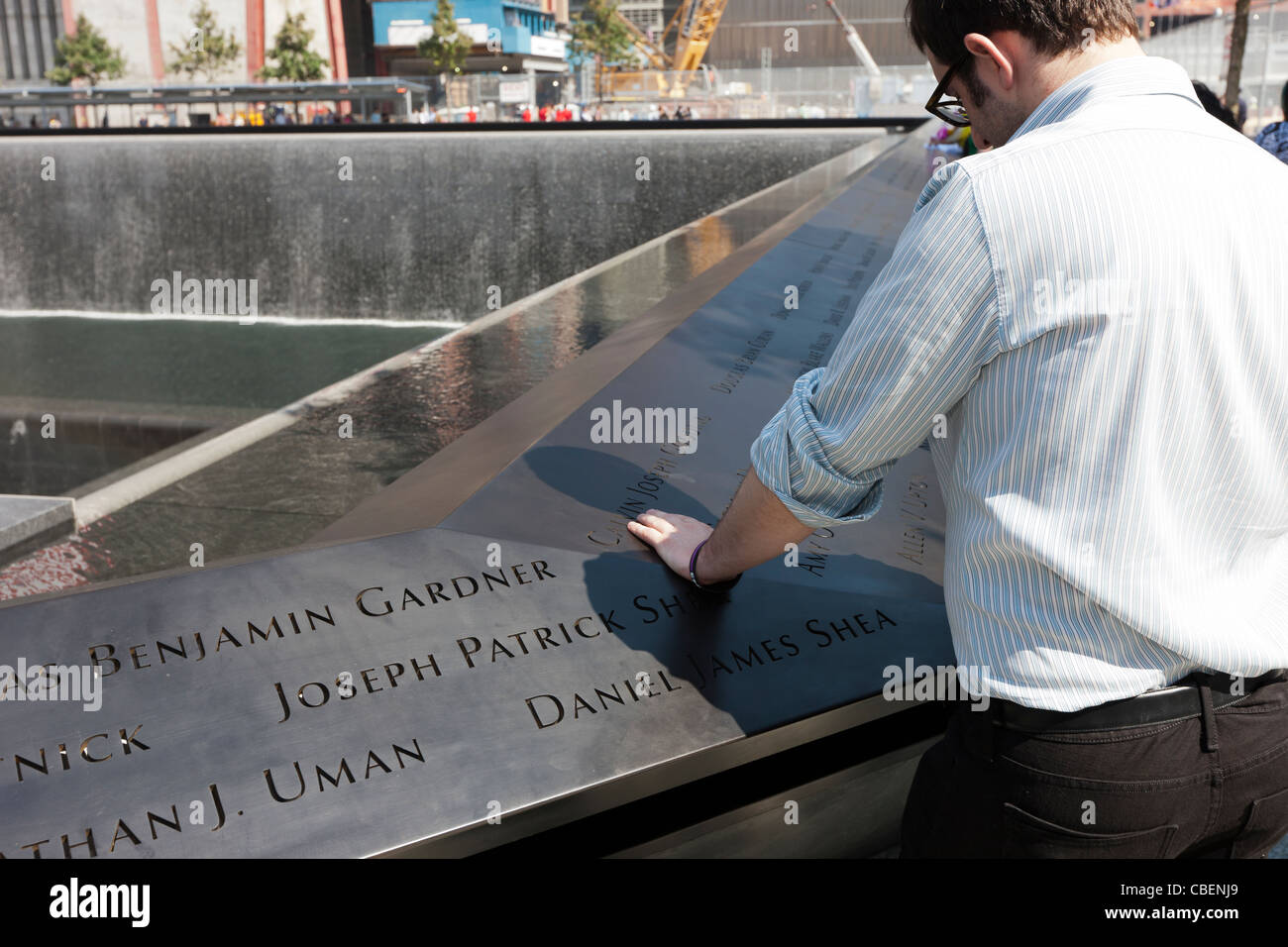 Un visitatore legge i nomi a livello nazionale 11 Settembre Memorial nella città di New York. Foto Stock