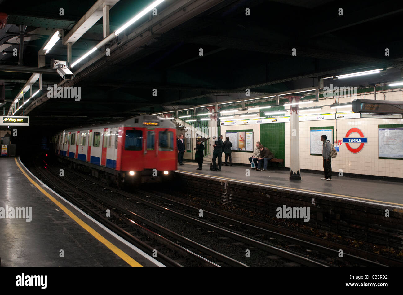 Un treno della District Line che arrivano al tempio La stazione della metropolitana di Londra, Inghilterra, Regno Unito Foto Stock