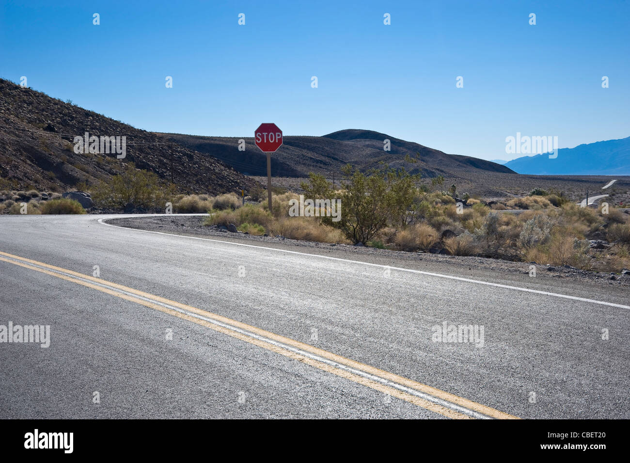 Deserto autostrada intersezione con il segnale di arresto, Nevada USA Foto Stock
