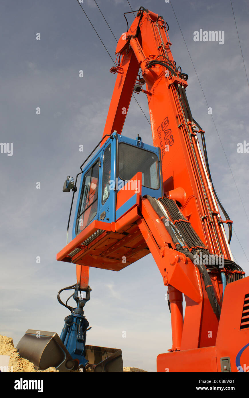 Escavatore rosso blu lavoro potenza di sabbia Foto Stock