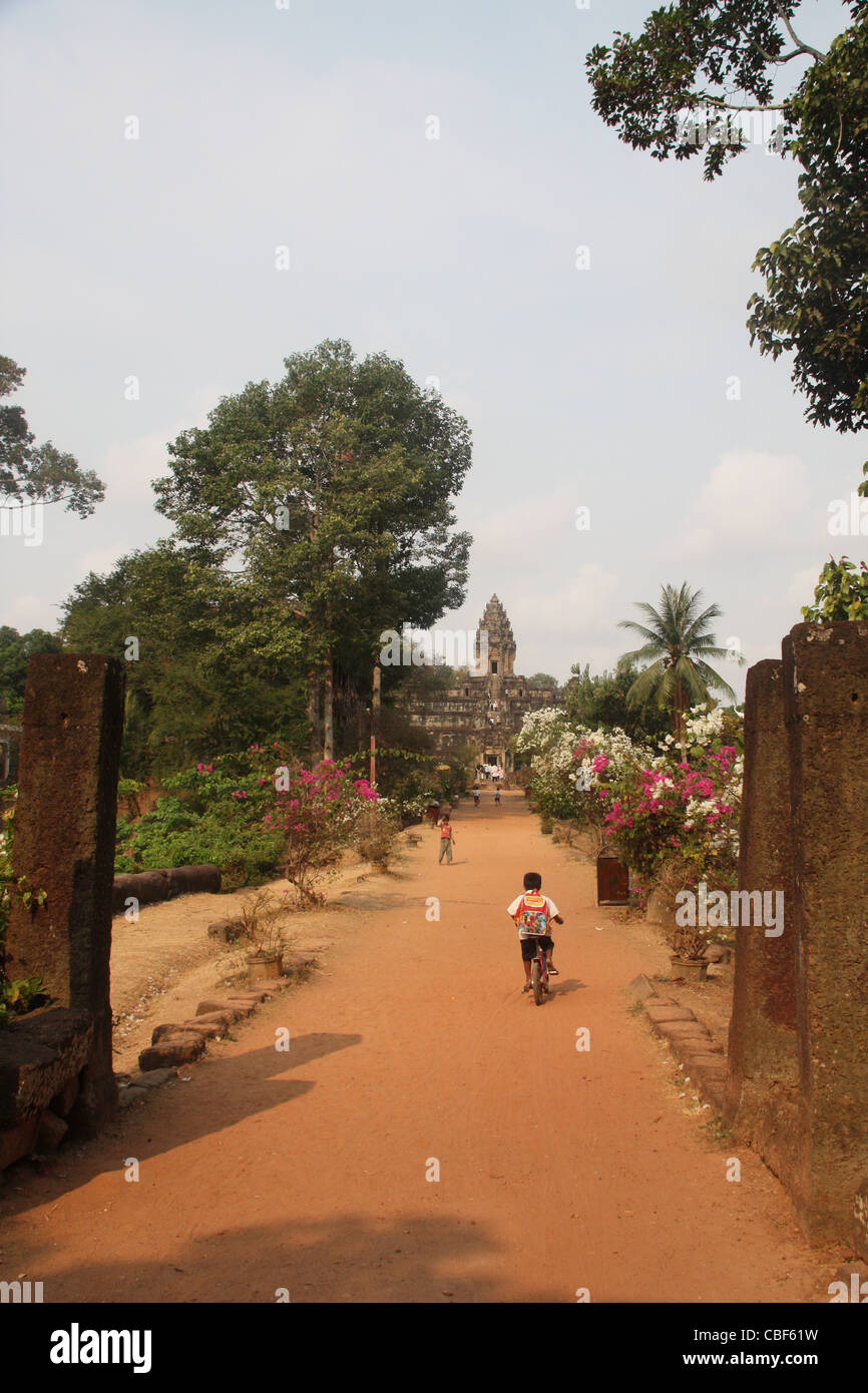 Piccolo Ragazzo di salire lungo il percorso al tempio cambogiano Foto Stock