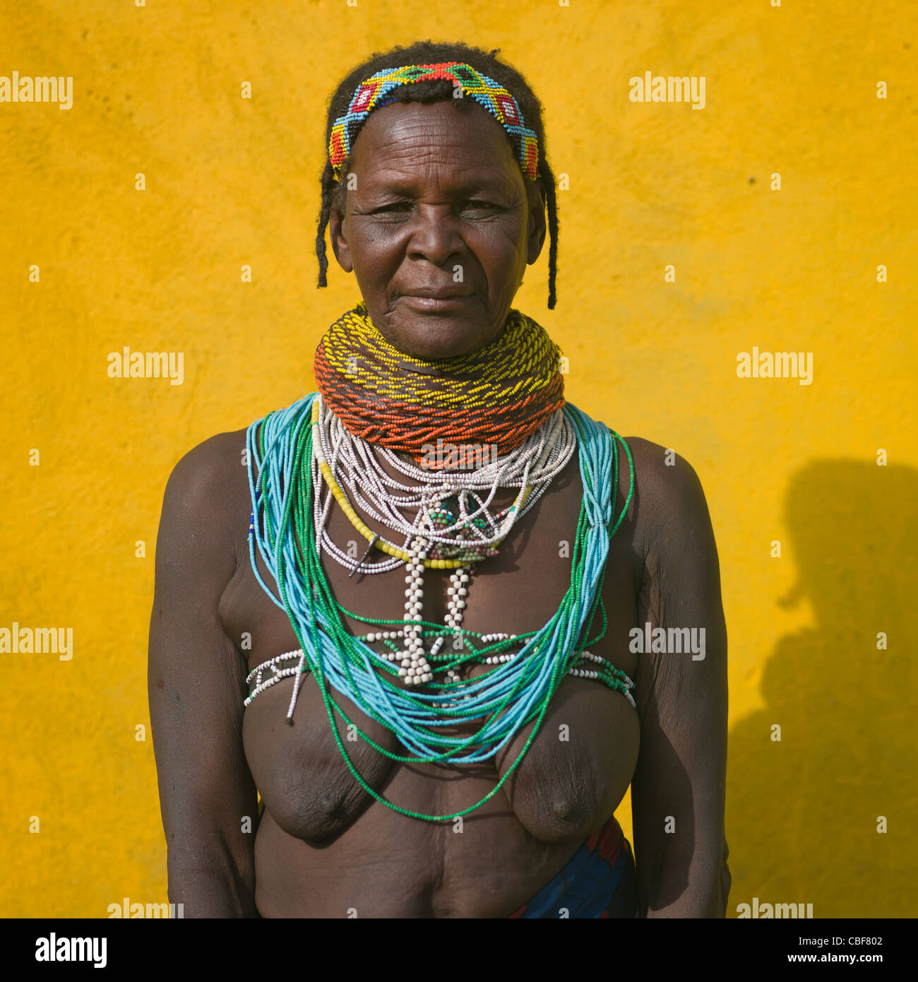 Vecchia donna Mwila con Vilanda Collana a Huila città mercato, Angola Foto Stock