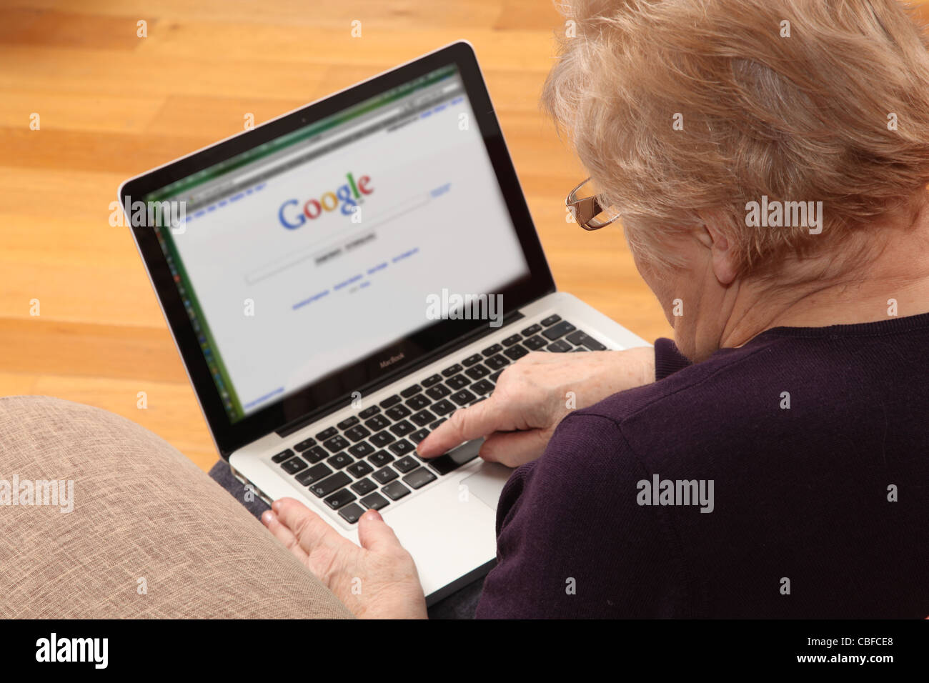 Donna matura usando il suo computer portatile, su internet con il motore di ricerca sullo schermo. Foto Stock