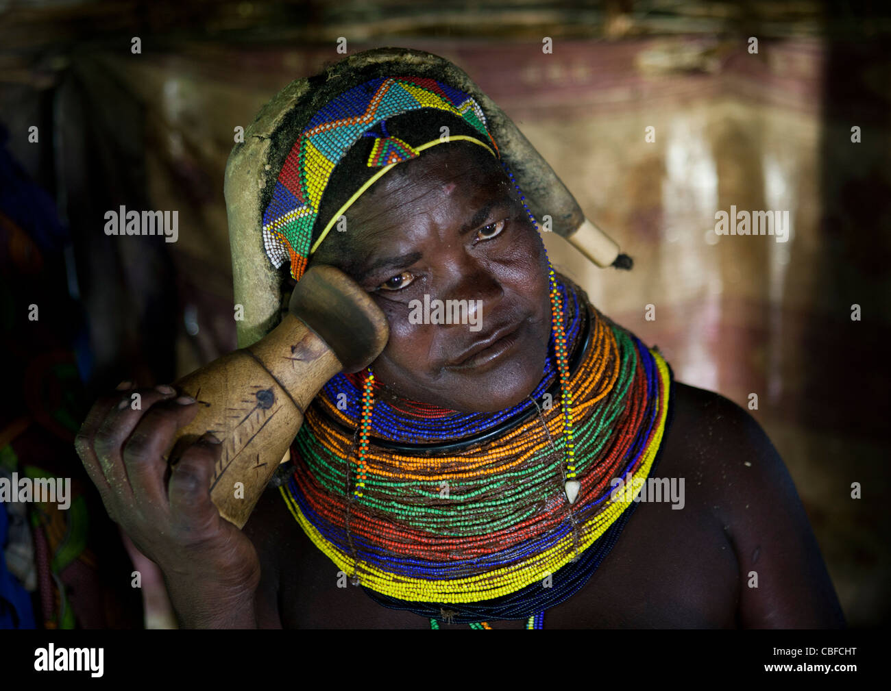 Mwila donna che mostra l'uso di un appoggiatesta, Angola Foto Stock