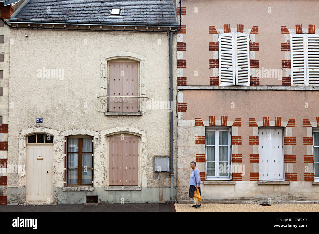 Donna oltrepassando case di città Toury Eure-et-Loire Francia Foto Stock