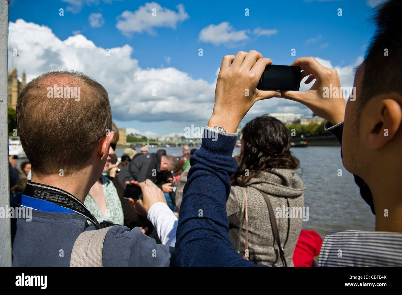 Persone su un fiume Thames Boat Tour guidato di fotografare i punti di riferimento di Londra, Regno Unito Foto Stock