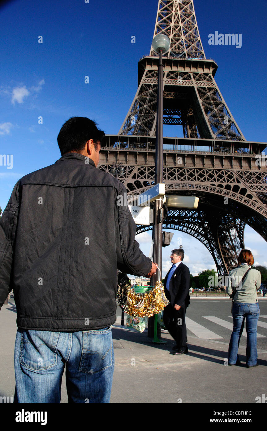 Uomo di vendita chiave turistica anelli souvenir della Torre Eiffel Foto Stock