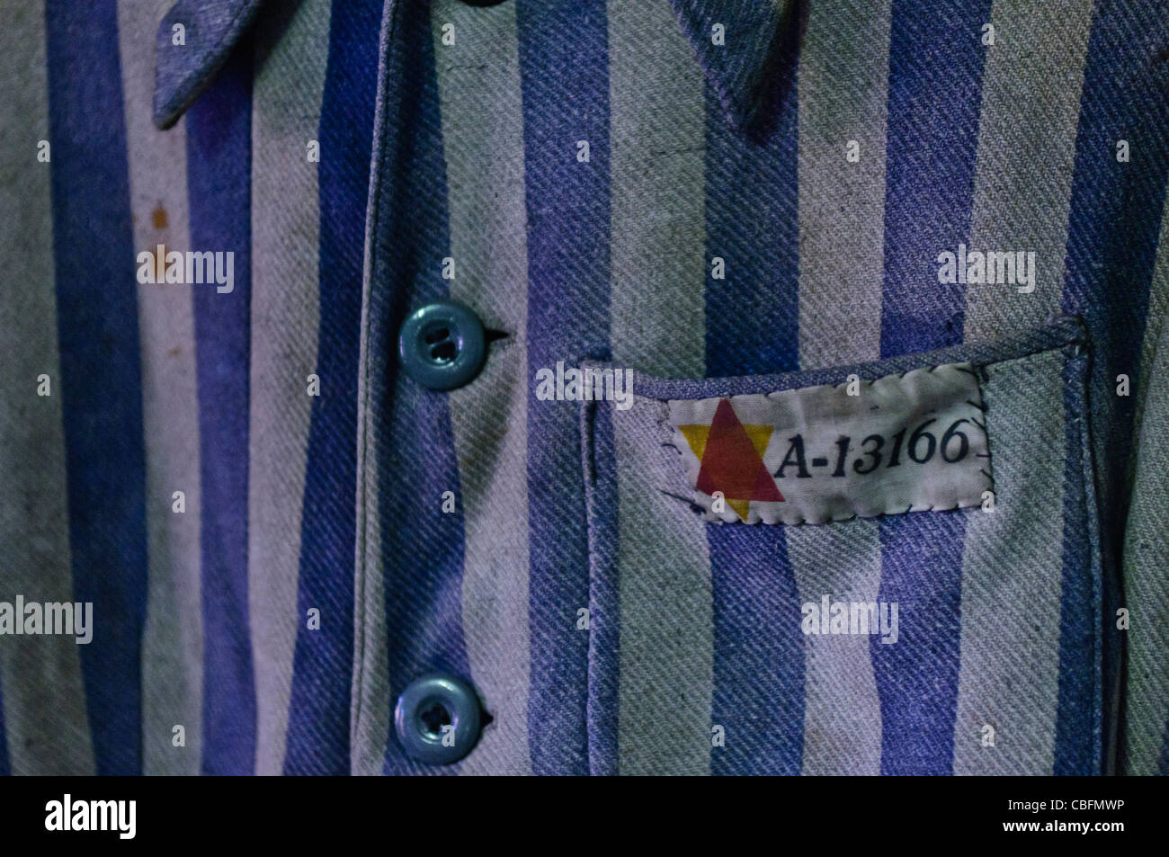 Uniforme di un prigioniero Ebreo ad Auschwitz I campo di concentramento nazista che mostra il rosso e il giallo triangoli Foto Stock