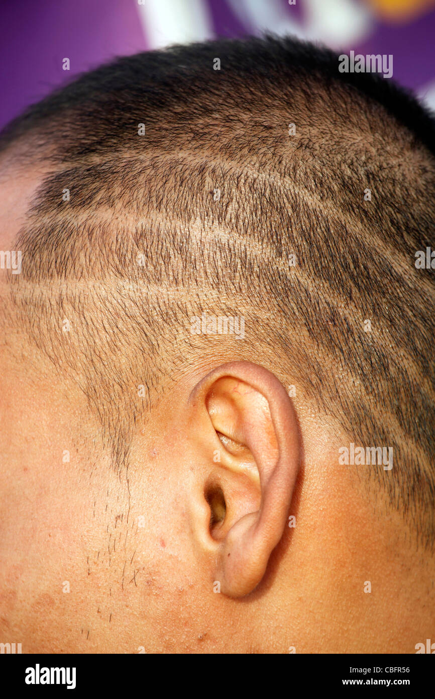 Testa di uomo con linee di chiudere tagliate i capelli rasata acconciatura a Patong, Phuket, Tailandia Foto Stock
