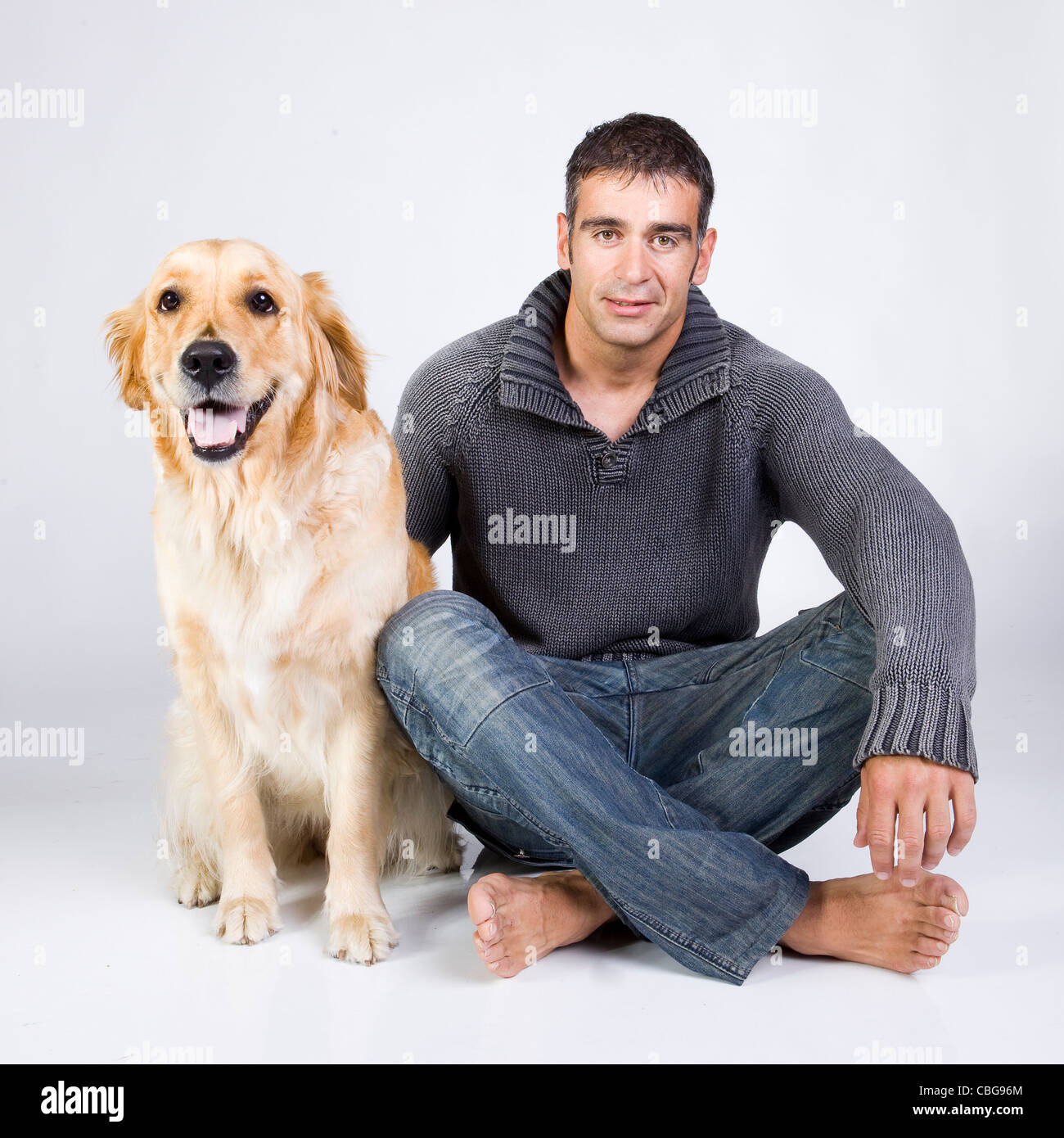 Attraente uomo giocando con il suo golden retriever Foto Stock