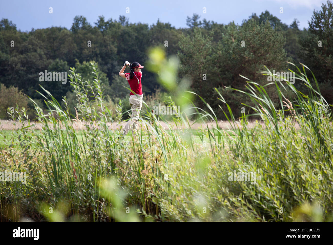 Un giocatore di golf femminile di rinvio off, concentrarsi sullo sfondo Foto Stock