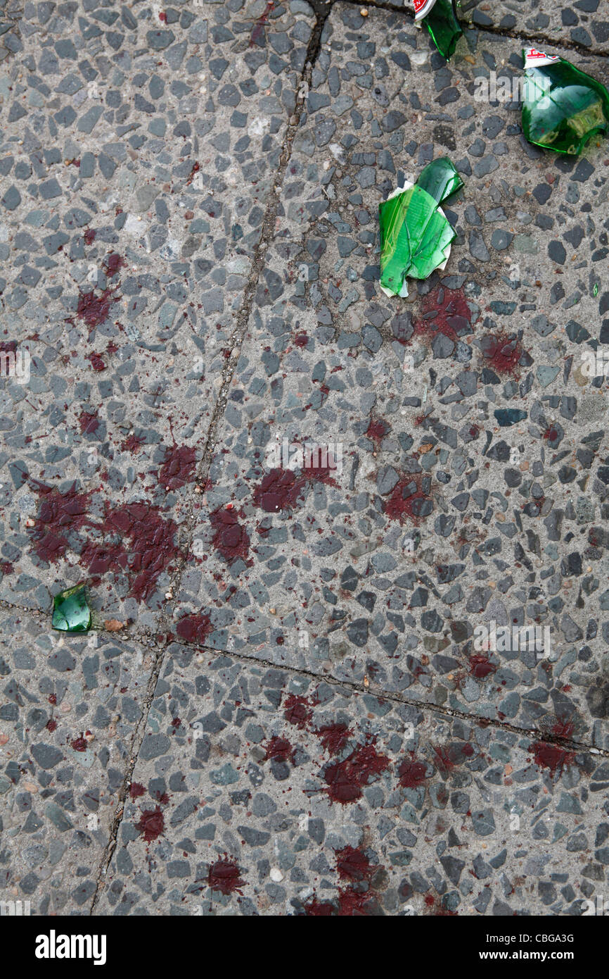 La rottura di una bottiglia di birra e opener il sangue su un marciapiede Foto Stock