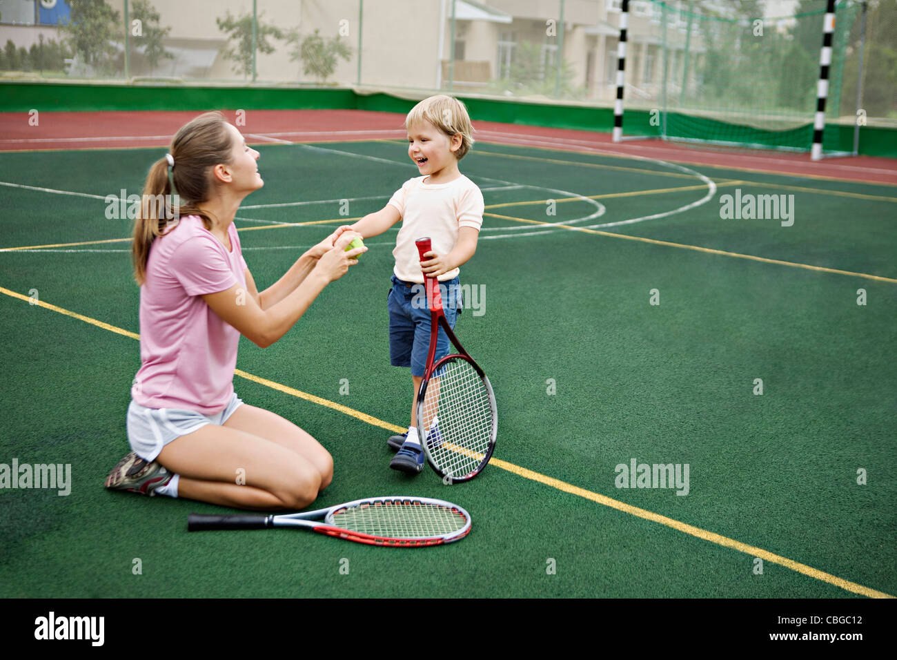Una madre e figlio divertirsi sul campo da tennis Foto Stock