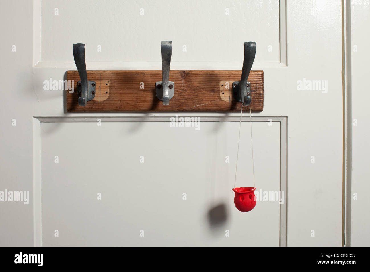 Rosso del clown naso pendente dal gancio appendiabiti su porta Foto Stock