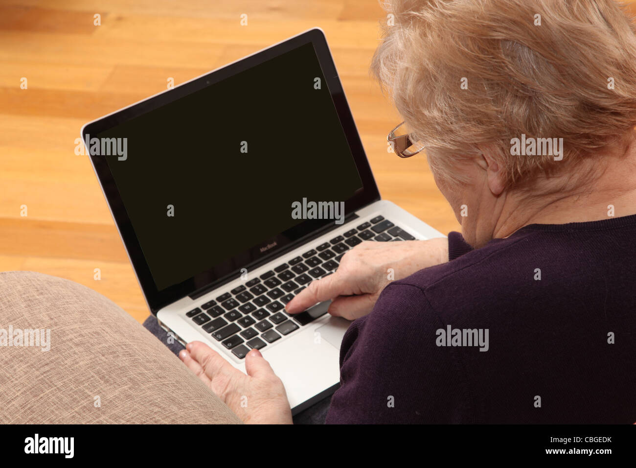 Donna matura usando il suo computer portatile con uno schermo vuoto pronto per i client grafico per essere inserita. Foto Stock