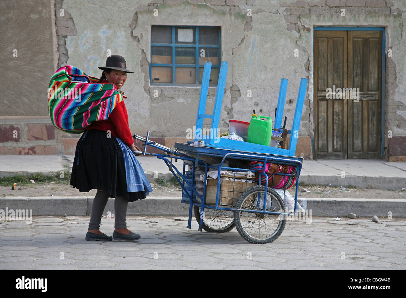 Vestito tradizionale nativa donna boliviana con pushcart andare al mercato in Challapata, Altiplano, Bolivia Foto Stock