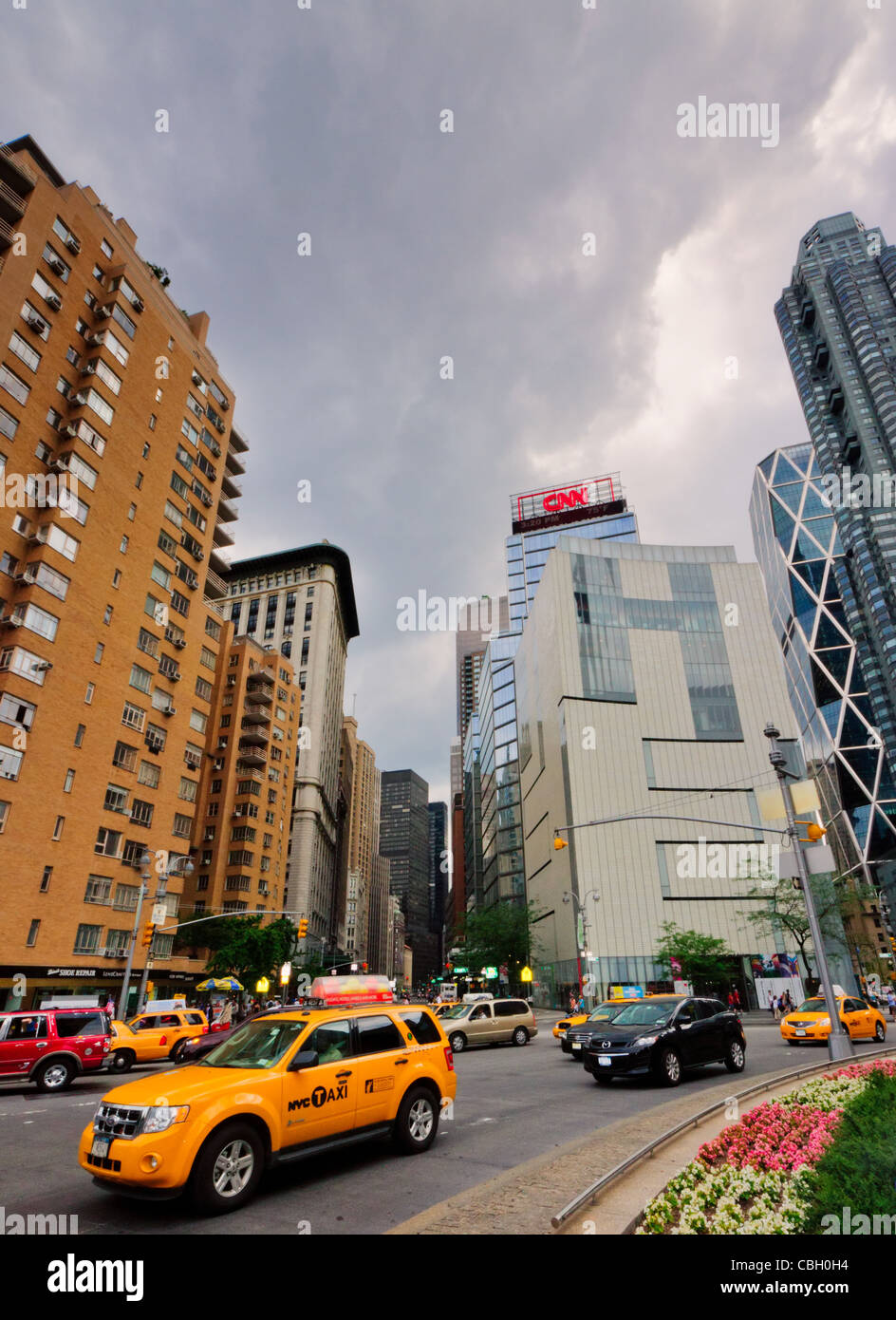 Columbus Circle, New York. Taxi e macchine che passano attraverso il cerchio, vicino al Museo delle Arti e Design e la torre della CNN. Foto Stock