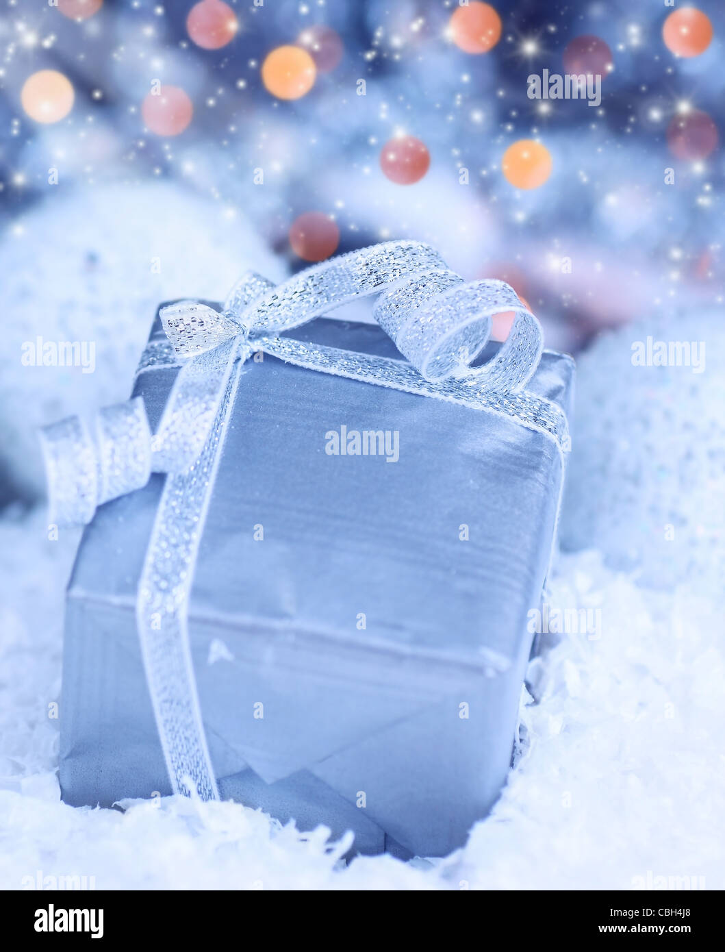 Vacanze inverno sfondo blu con la presente confezione regalo, nastro argentato ornamento & neve natalizia decorazione Foto Stock