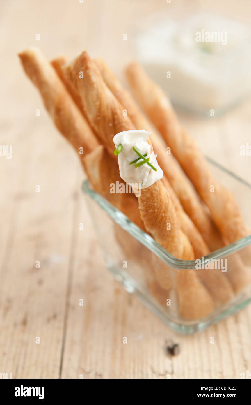 I bastoncini prodotti di pasta francese servita su un partito come uno snack con crema dip con erba cipollina Foto Stock
