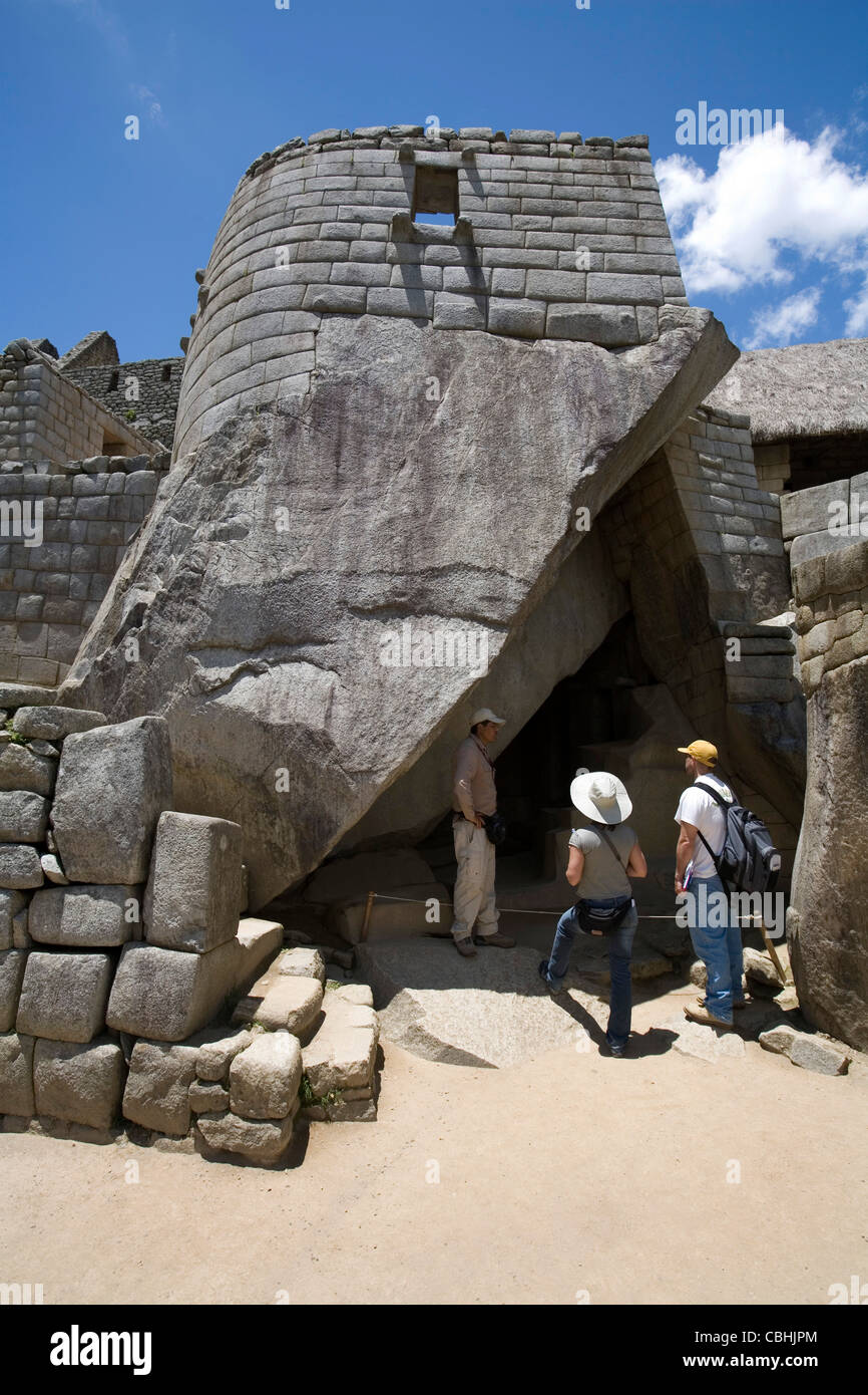 Una guida locale spiega i dettagli del tempio di Sun per i visitatori di Machu Picchu, Peru' Foto Stock