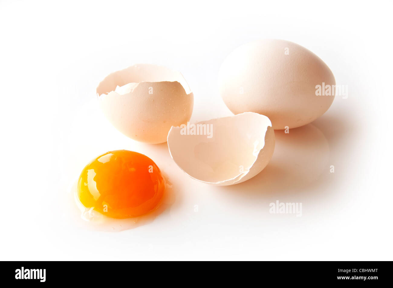 Due uova e un tuorlo su sfondo bianco Foto Stock