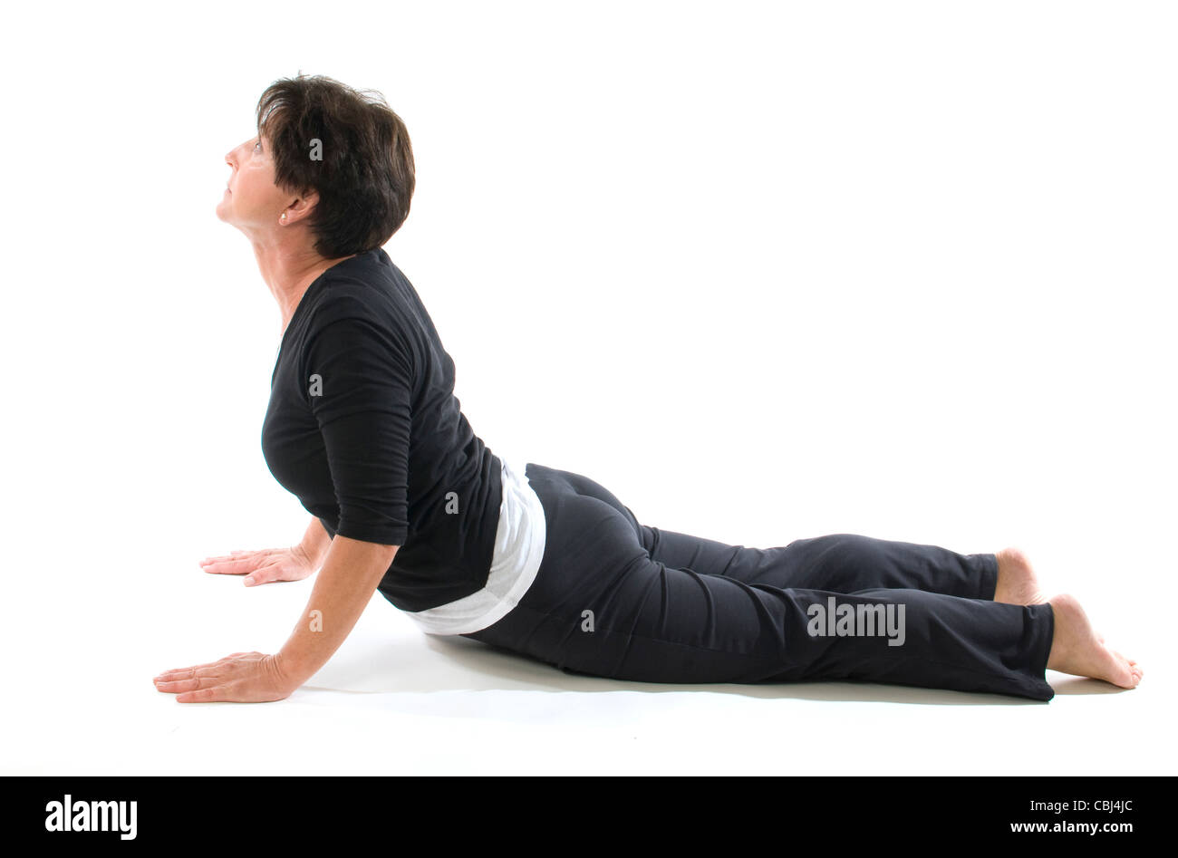 La mezza età senior donna esercizi yoga posizione del cobra premere a gomito Foto Stock