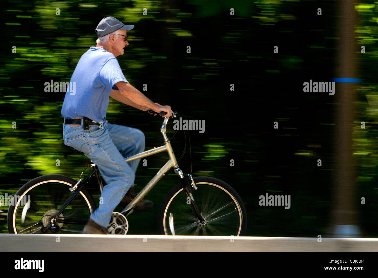 Uomo in bicicletta lungo il greenbelt in Julia Davis Park, Boise, Idaho, Stati Uniti d'America. Foto Stock