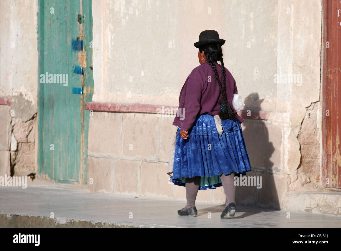 Indigeni donna boliviana con trecce in abito tradizionale indossando Bowler cappello e mantello in corrispondenza di Uyuni, Altiplano, Bolivia Foto Stock