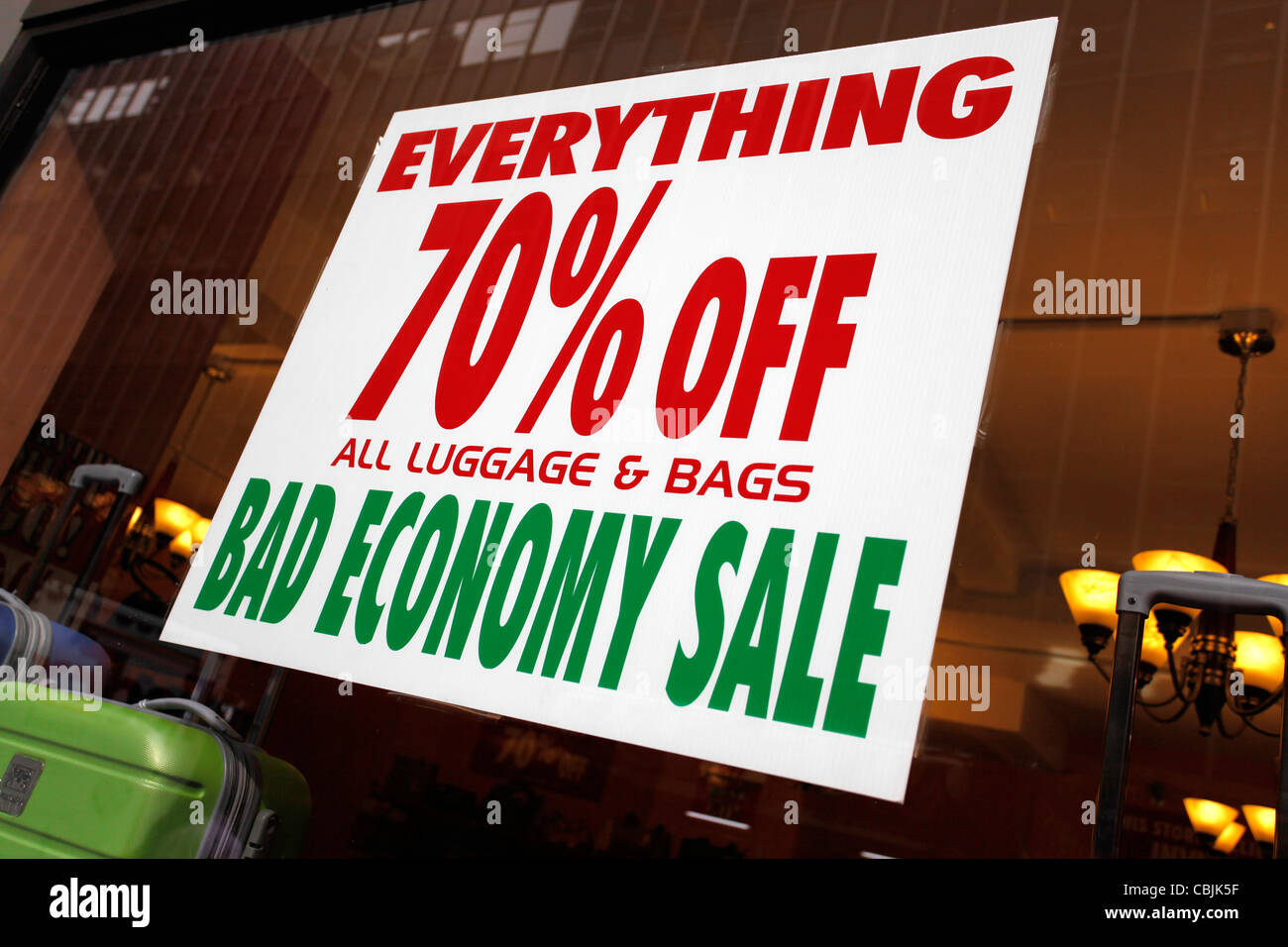 Una cattiva economia vendita firmare con il 70% di sconto in un bagaglio e valigia shop, come un risultato della crisi e recessione economica a New York, l'unità Foto Stock