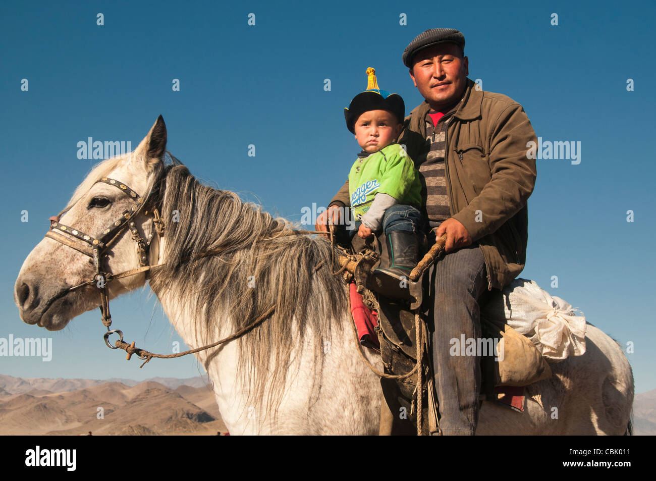 Il kazako padre e figlio a cavallo in Bayan-Ölgii in Mongolia occidentale Foto Stock