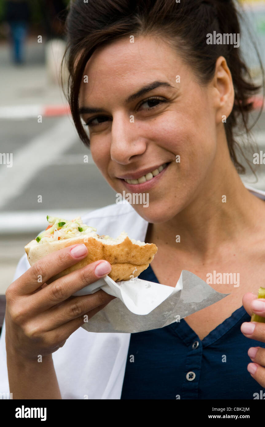 Una donna israeliana gode di Falafel in pane pita. Foto Stock