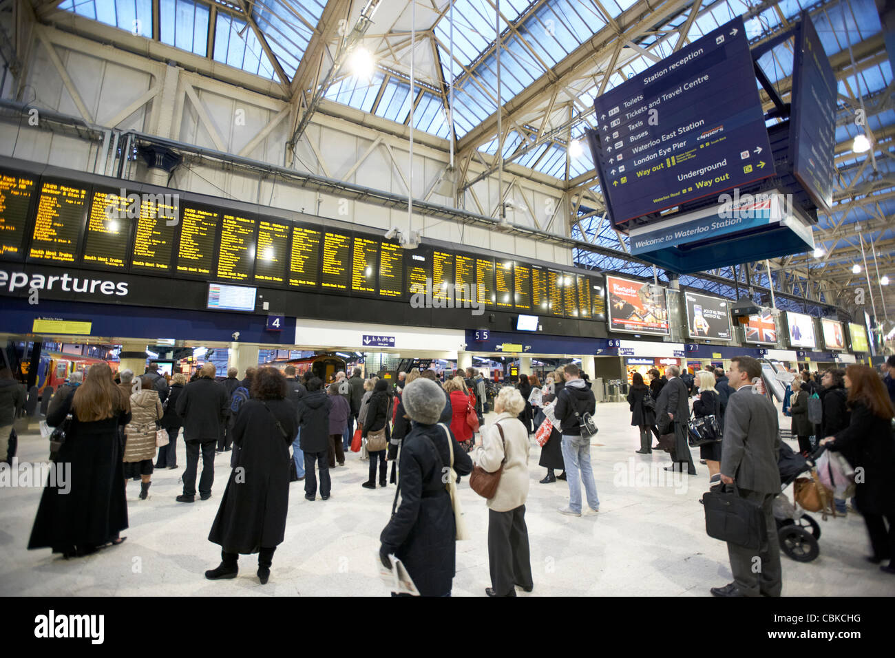 Le persone che cercano a livello locale e nazionale informazioni treno tavole a Waterloo Stazione ferroviaria Londra Inghilterra Regno Unito Regno Unito Foto Stock