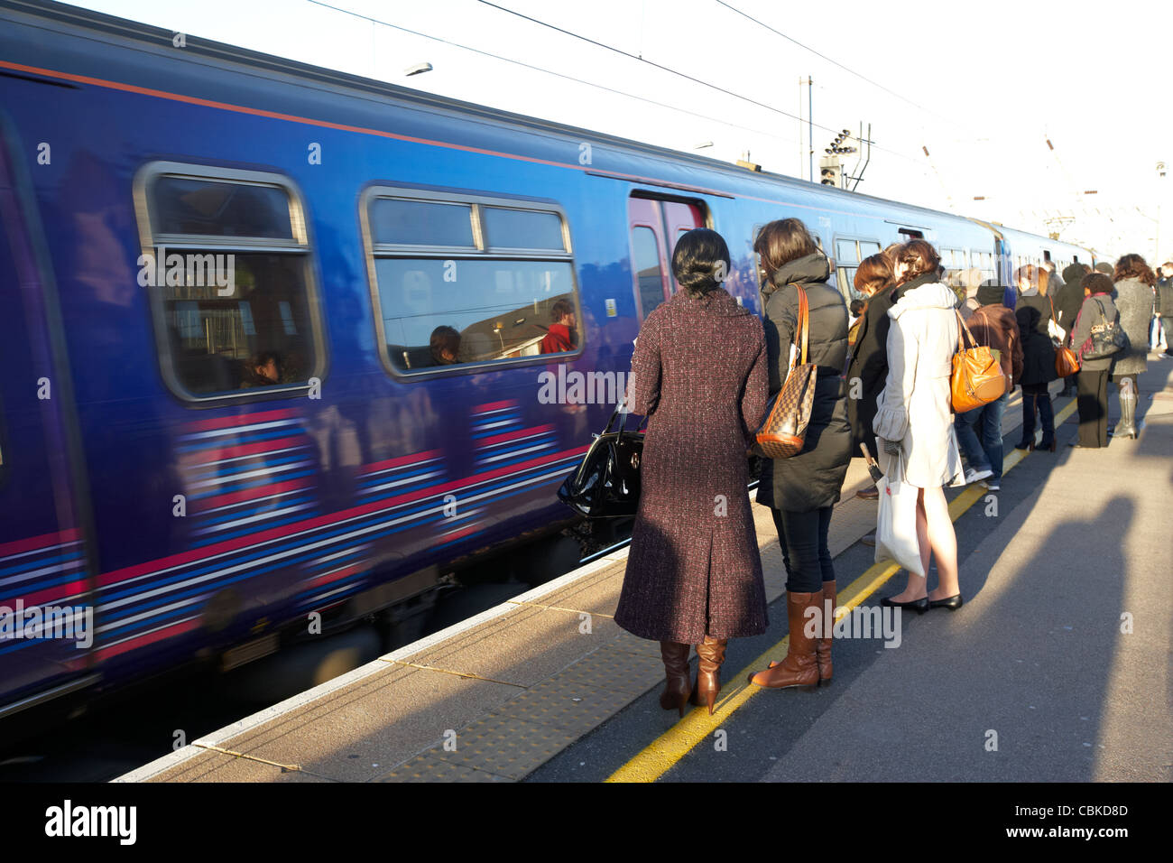 Persone in attesa di salire a bordo del treno in arrivo a cricklewood ferrovia stazione ferroviaria Londra Inghilterra Regno Unito Regno Unito Foto Stock