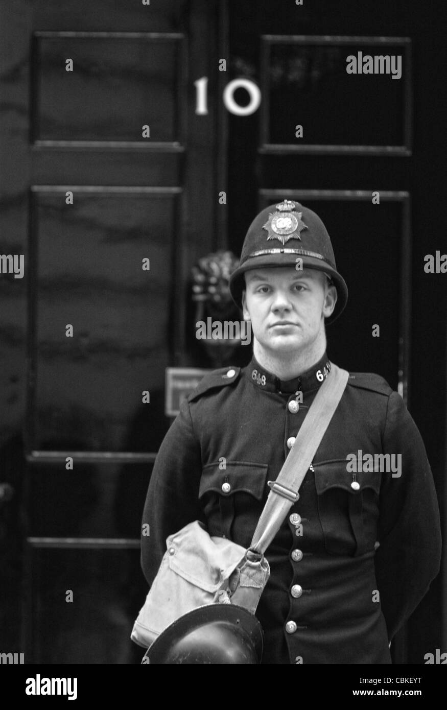 Un attore vestito come un 1940 British poliziotto si erge al di fuori 10 Downing Street a Westminster Londra. Foto di James Boardman Foto Stock