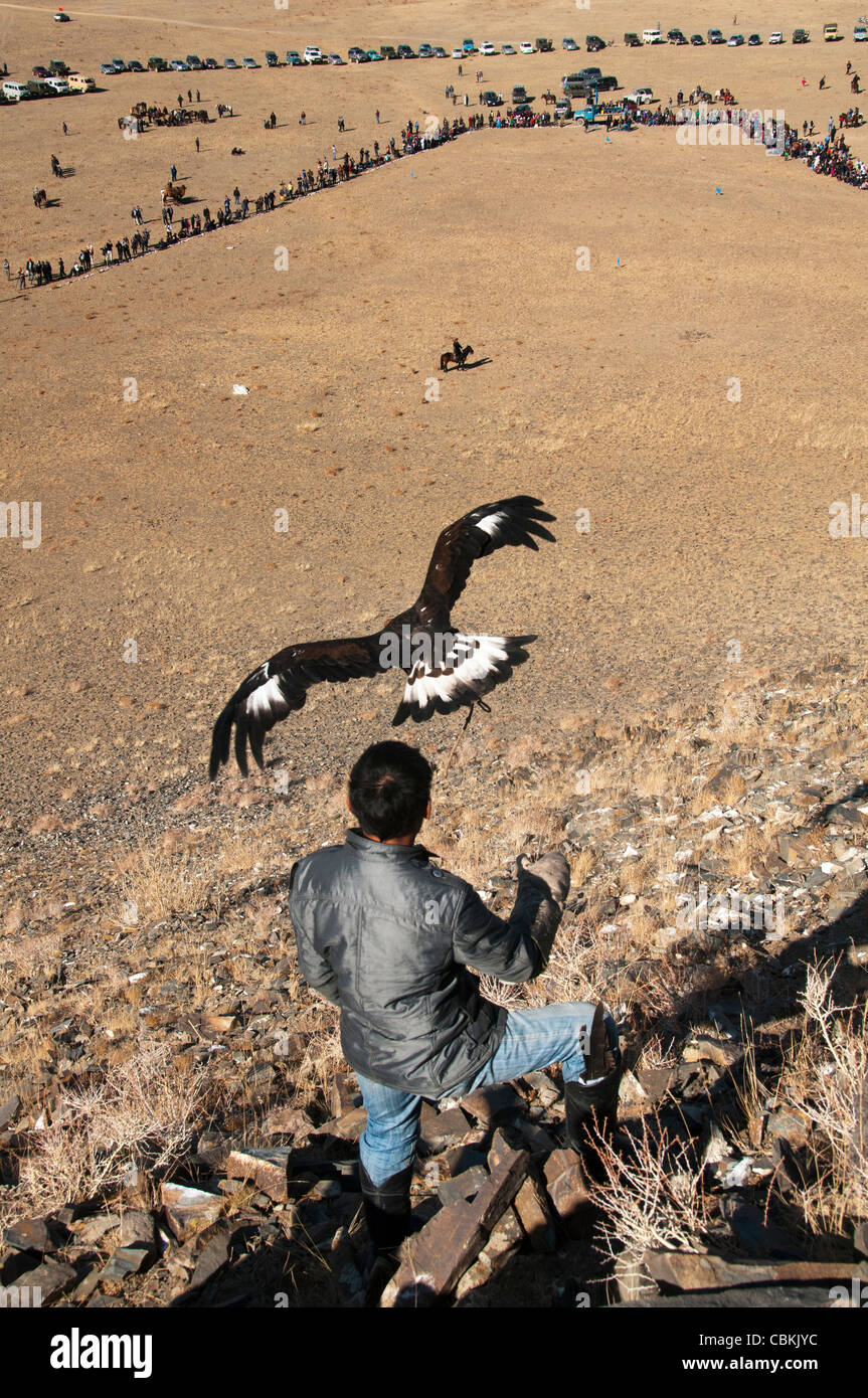 Un aquila kazaka hunter lascia il suo golden eagle fly in Altai regione del Bayan-Ölgii in Mongolia occidentale Foto Stock