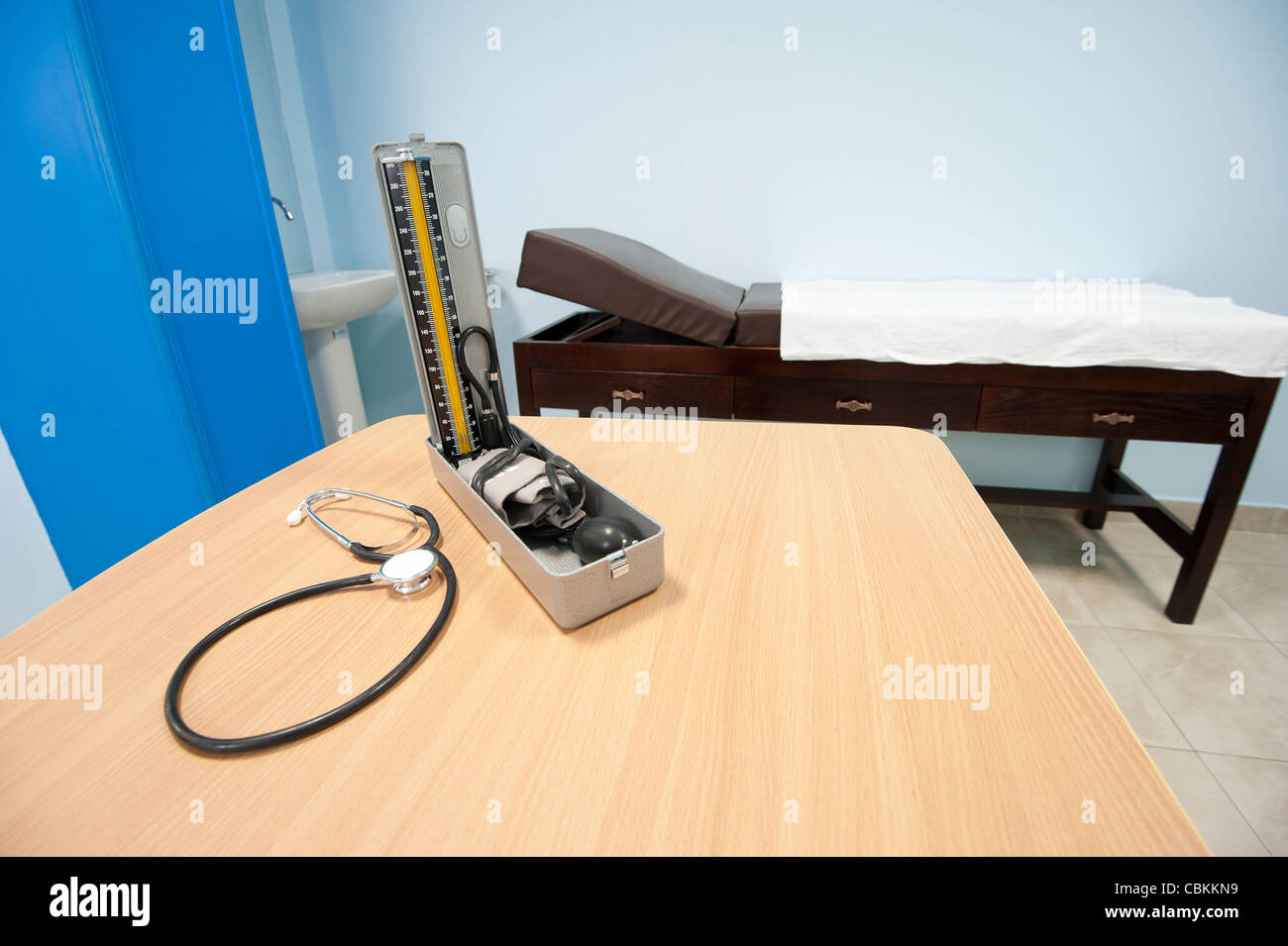 Apparecchio per la misurazione della pressione sanguinea e uno stetoscopio in un ufficio medici con banco di esame Foto Stock