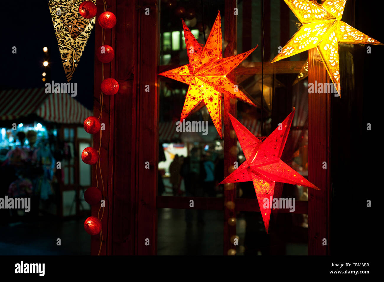Shopping di Natale a Berlino. Indian su carta a mano le stelle per vendere in un mercato di Natale in piazza Potsdamer Platz. Foto Stock