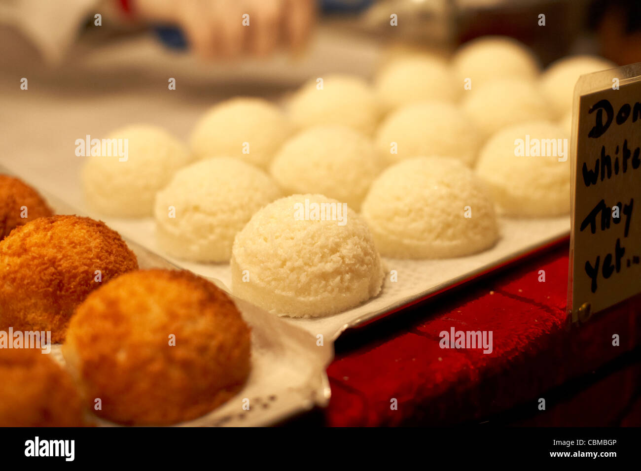 Amaretti al cocco pronto per essere cotto su un vassoio su una fase di stallo a Belfast Irlanda del Nord Regno Unito Regno Unito Foto Stock