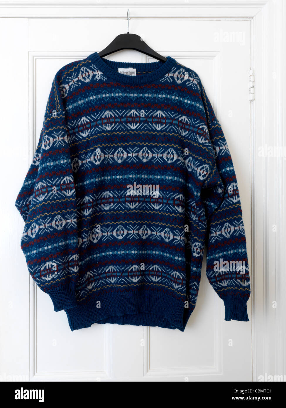 Blu di lana modellato il ponticello realizzato nel Fair Isle Scozia appeso su una porta Foto Stock