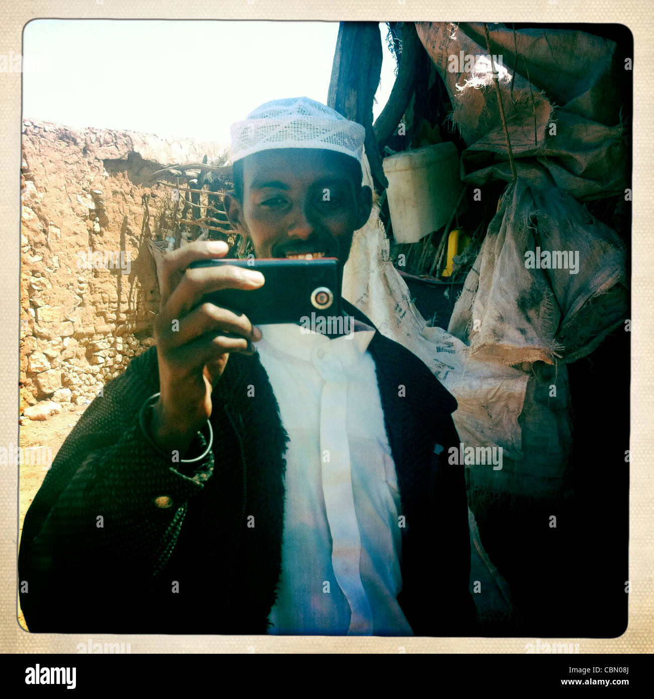 Giovane uomo nero con il telefono cellulare sta immagine Degehabur Somalia Foto Stock